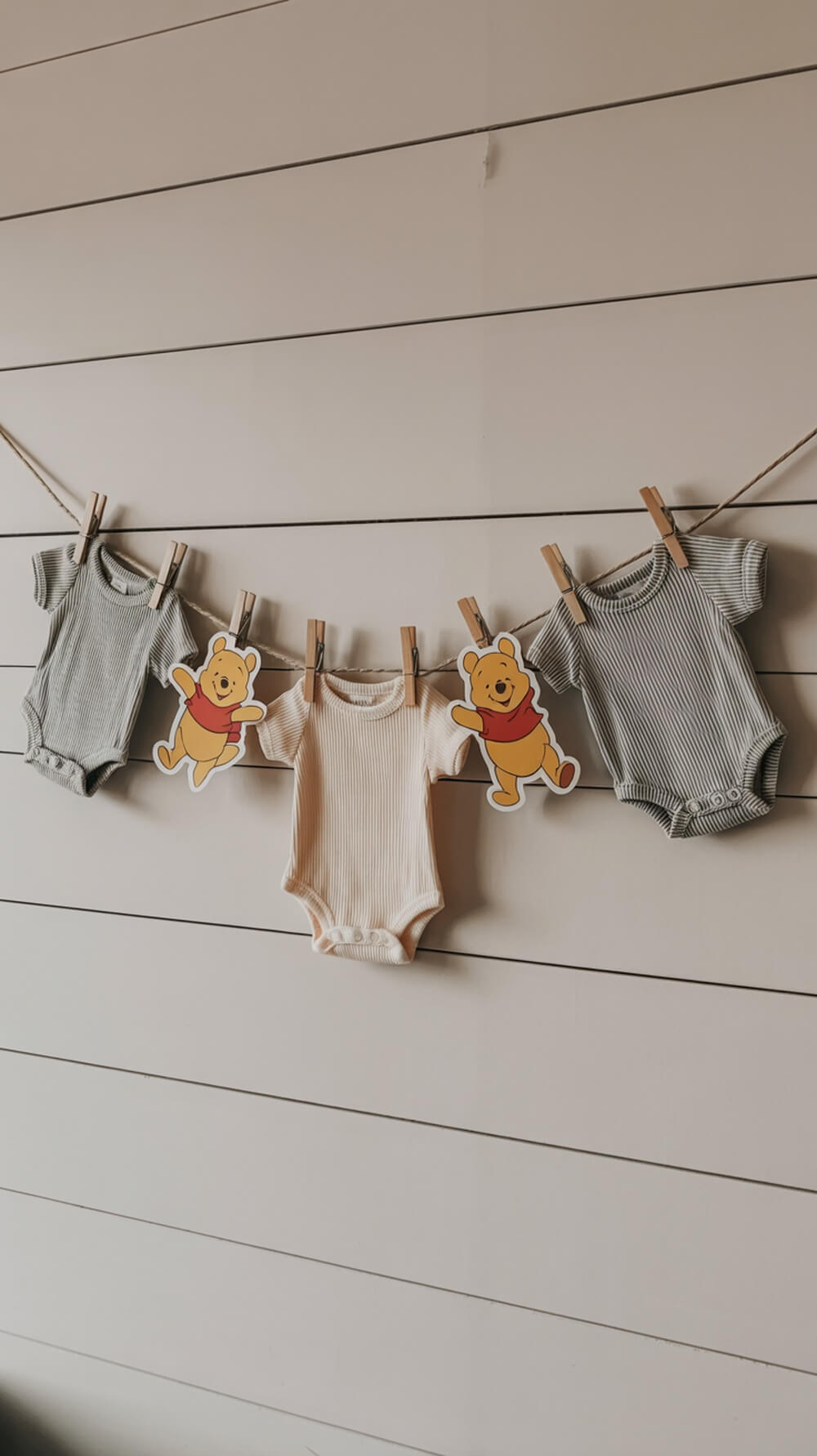 Baby clothesline display featuring adorable baby onesies and Winnie the Pooh decorations.