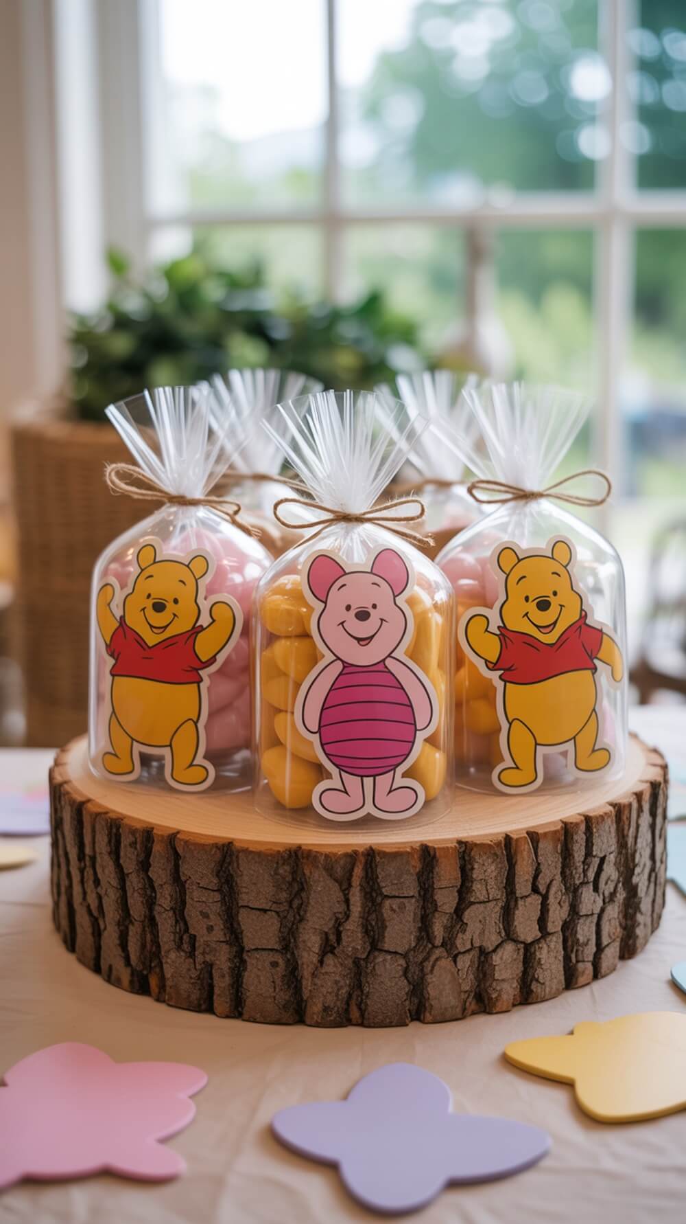 Winnie the Pooh themed party favors in clear bags with colorful candies and illustrations of Pooh and Piglet on a wooden slice.