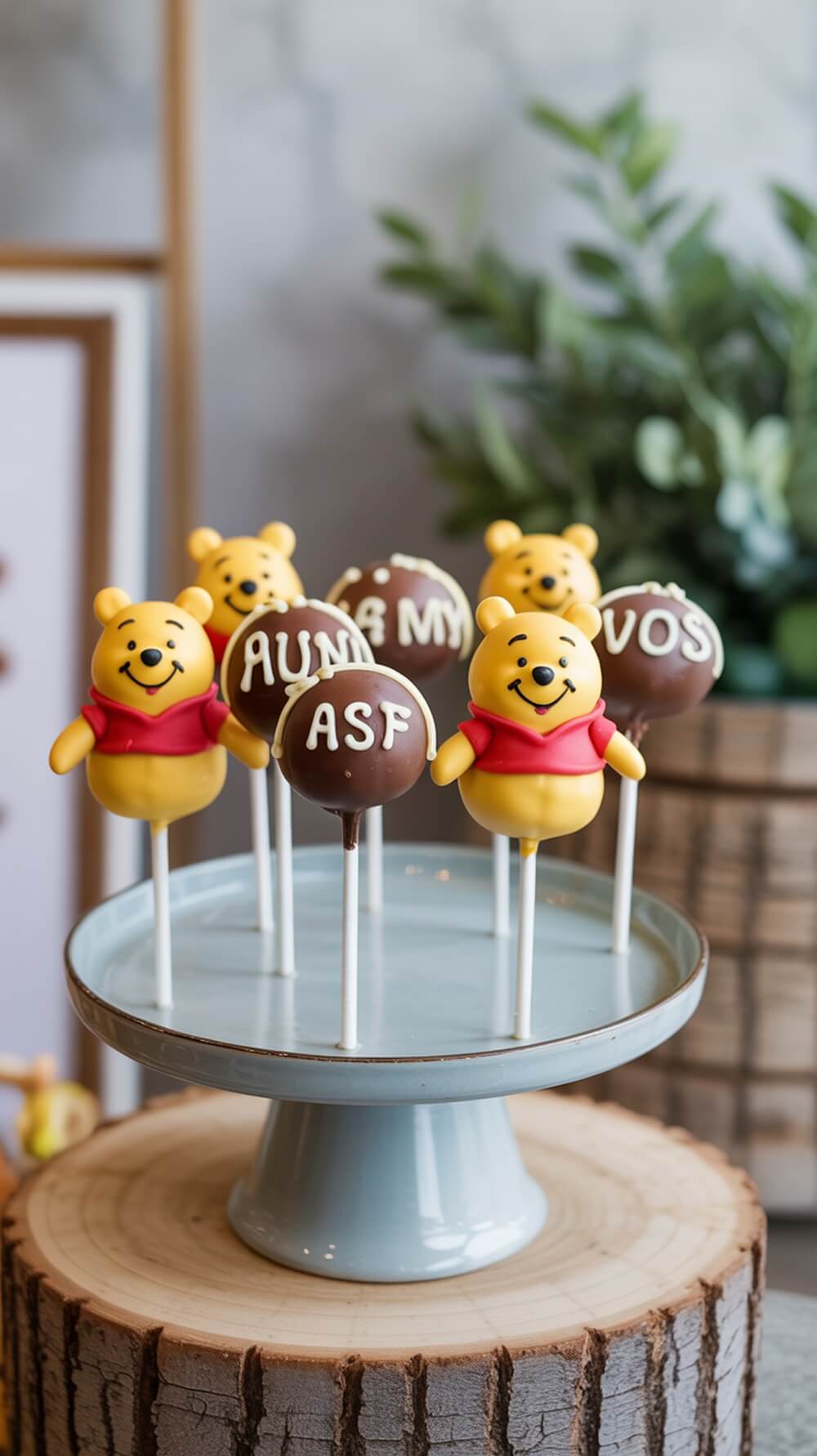 A display of Pooh Bear themed cake pops on a stand, featuring cute designs and fun messages.