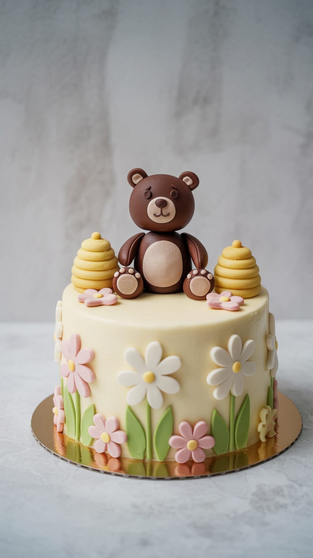 A cute bear cake decorated with flowers and honeycombs, perfect for a baby shower.