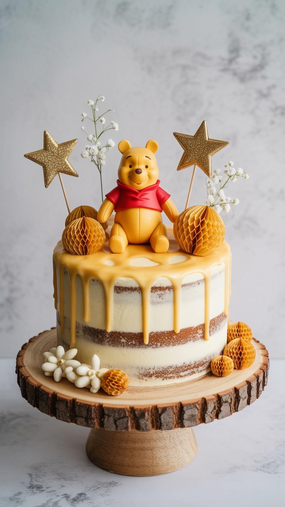 A cake topped with a Winnie the Pooh figurine, honeycomb decorations, and flowers, set on a wooden stand.
