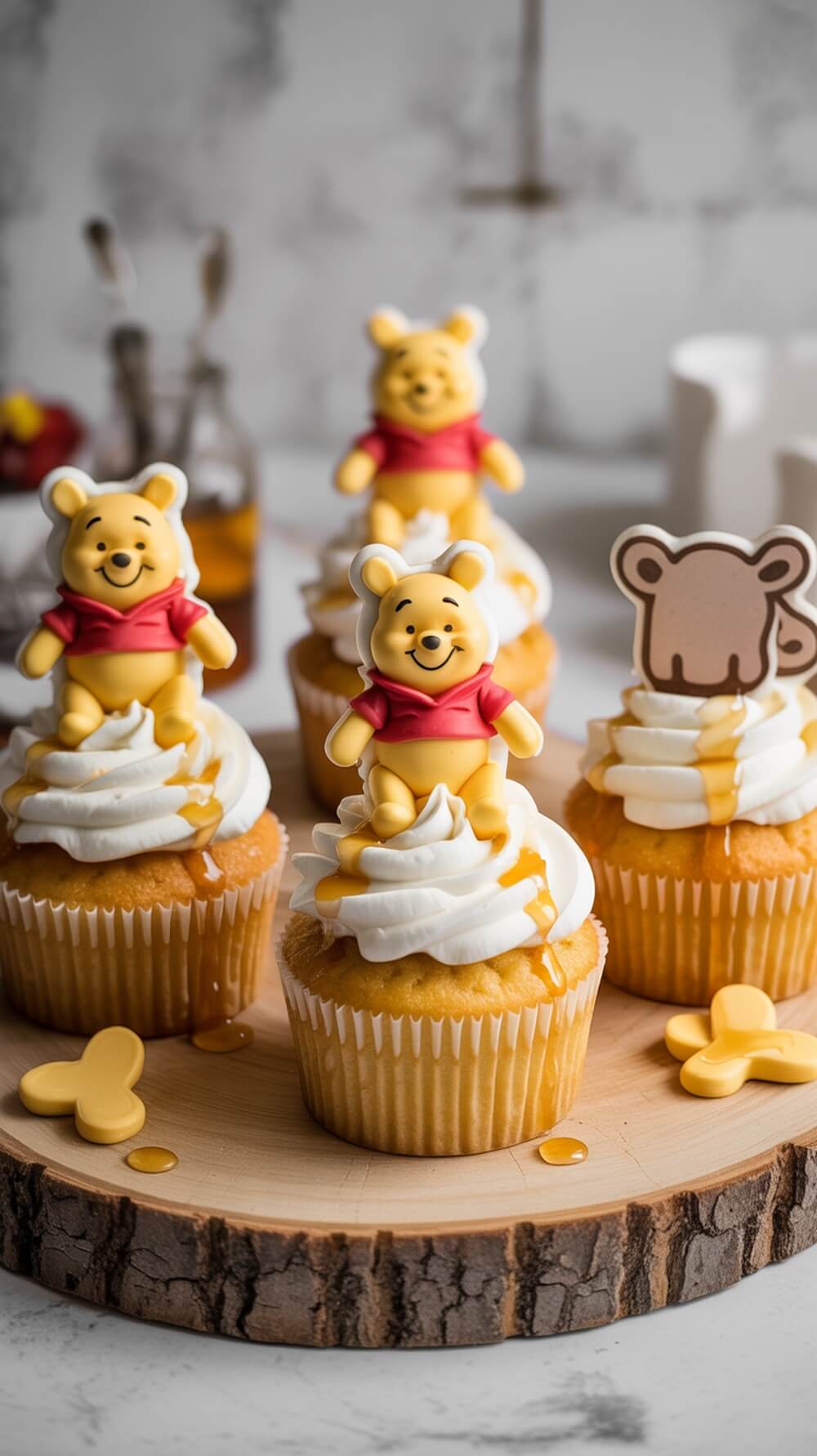 Pooh Bear themed cupcakes with frosting and honey drizzle on a wooden platter