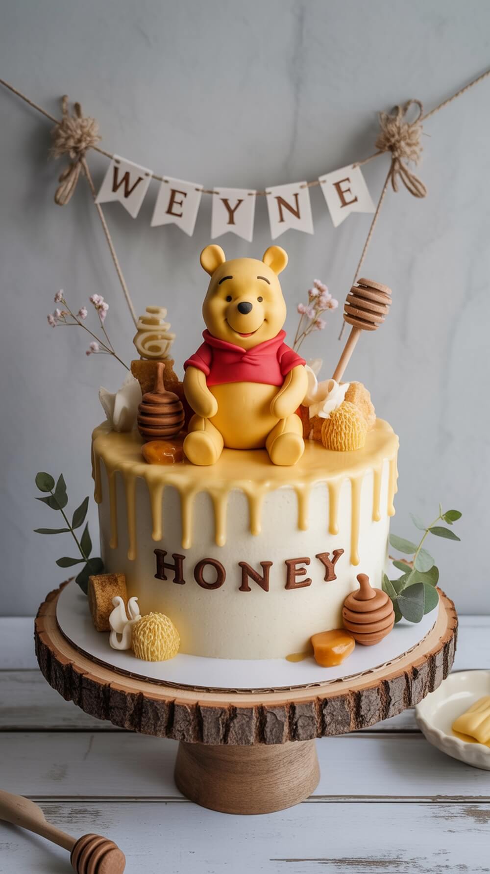 A Winnie the Pooh themed baby shower cake with honey decorations and a Pooh figure on top.